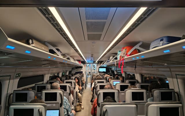 AVE車内の様子|座席上の荷物棚にスーツケースが並んでいる