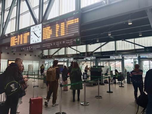 サンティアゴ駅の出発ロビー。電光掲示板と荷物検査の行列が見える。