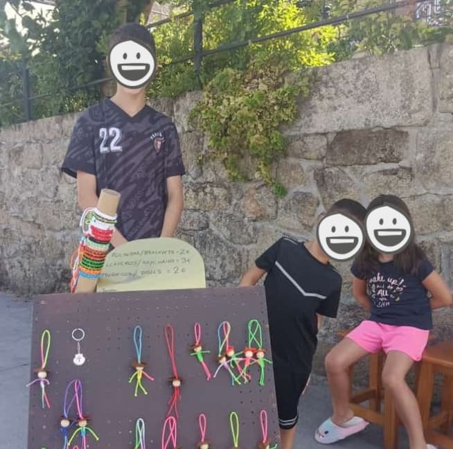 ポルトガルの道沿いで修学旅行の資金を稼ぐために手作り人形を売る子供達