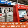 バルセロナの地下鉄駅でTMB券売機を操作する手。画面にはT-casualの購入画面が表示されており、背景には赤い地下鉄車両とSagrada Familia駅の表示が見える。
